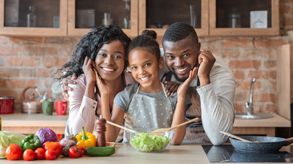 Lovely family cooking healthy dinner together at kitchen