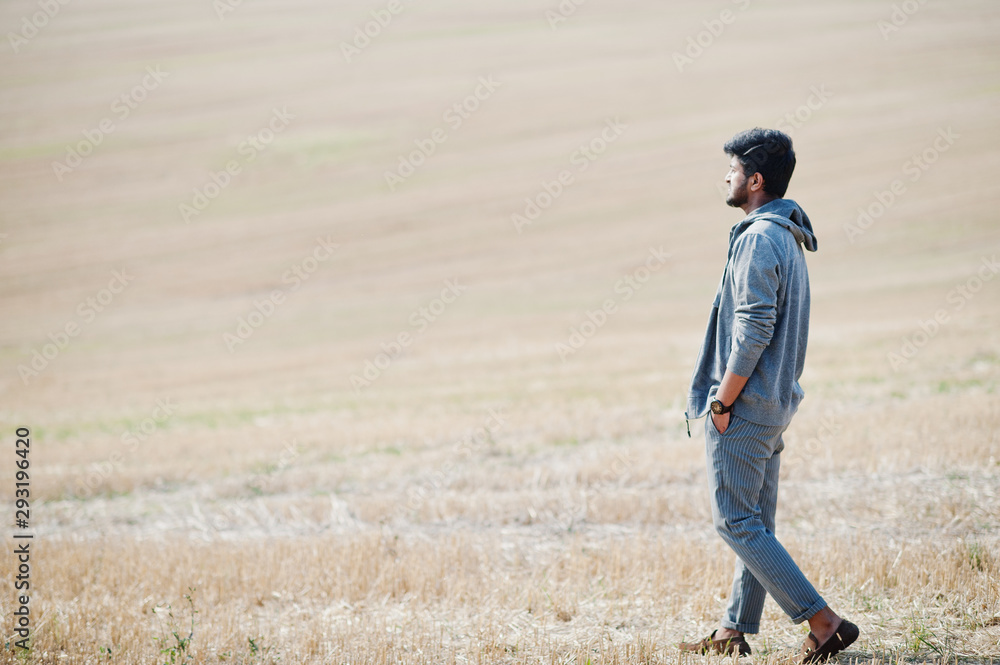 Indian man at casual wear posed at field alone. Indian man at casual wear posed at field alone.