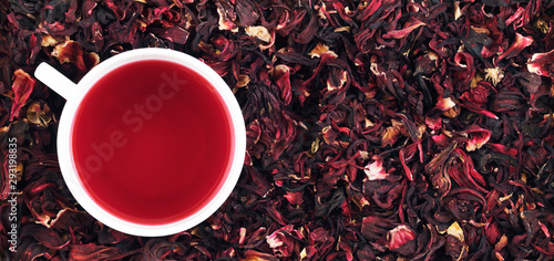 Cup of hibiscus tea on the leaves. Panorama. Banner. 