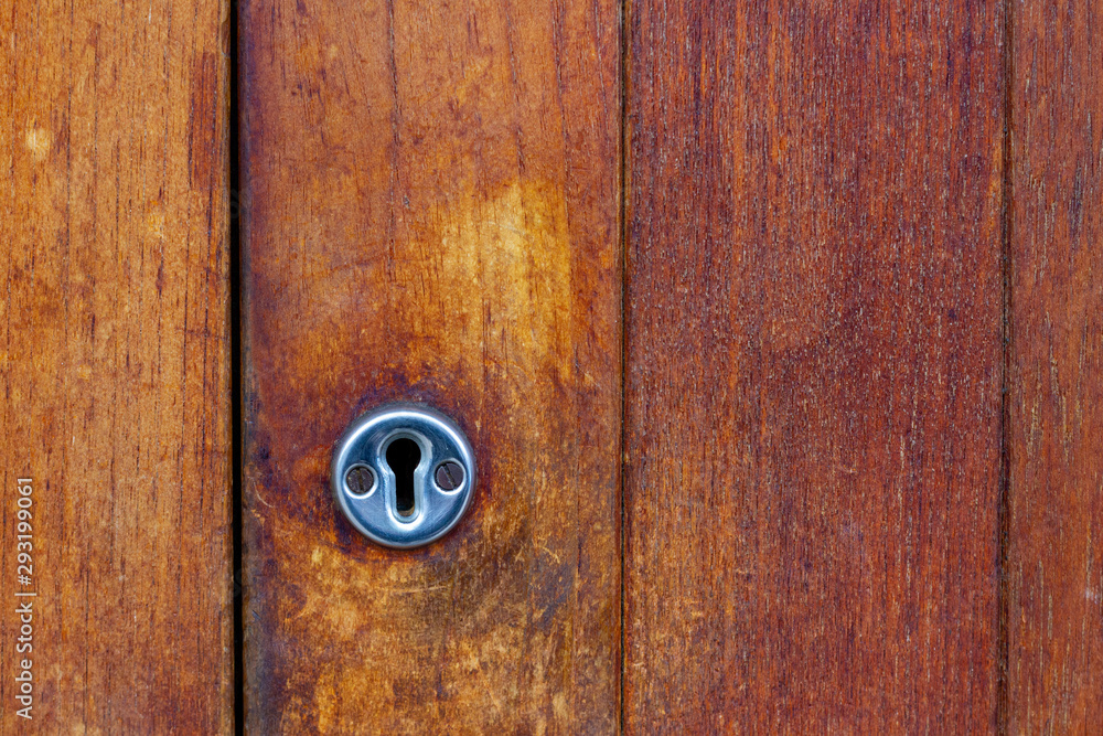 Fototapeta premium Silver key hole on an old wooden door