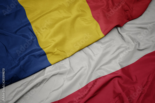 waving colorful flag of poland and national flag of romania.