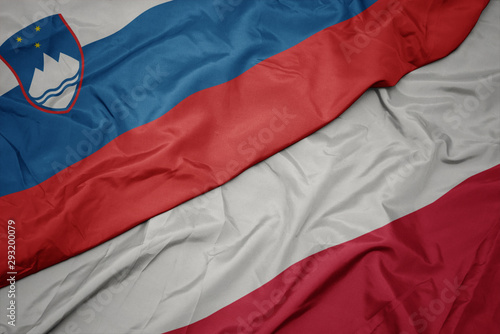 waving colorful flag of poland and national flag of slovenia.