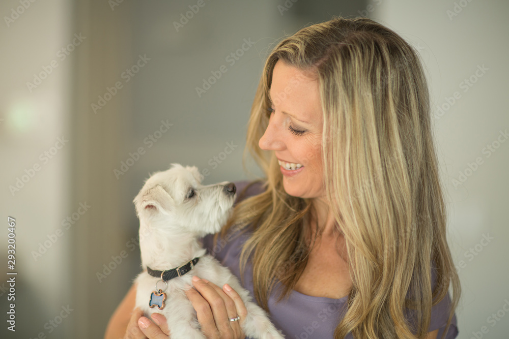 Portrait of a woman hugging and smiling at her dog. Portrait of a woman hugging and smiling at her dog.