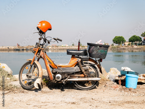 old orange motorcycle of a fisherman photo