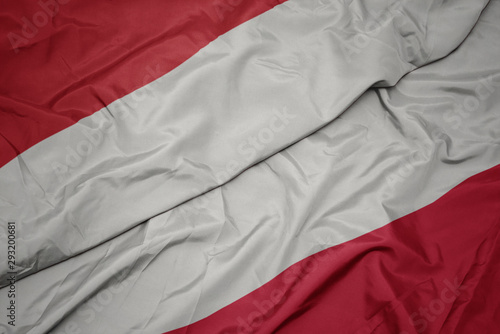 waving colorful flag of poland and national flag of indonesia.