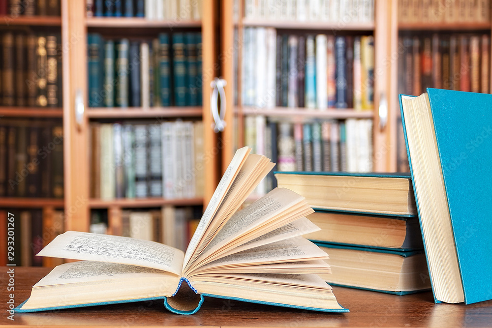 Books lie on the table against the background of bookcases. Books lie on the table against the background of bookcases.