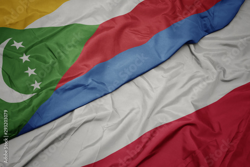 waving colorful flag of poland and national flag of comoros.