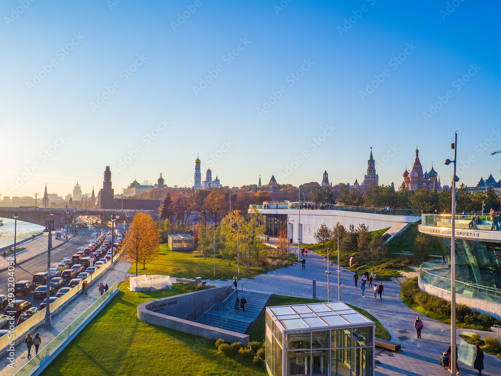 Fototapeta premium Beautiful view of Zaryadye landscape park with the steeples of the Kremlin and the St Basil`s Cathedral in the background on a sunny autumn evening.