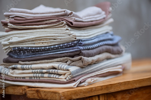 A stack of linen textiles on a wooden table