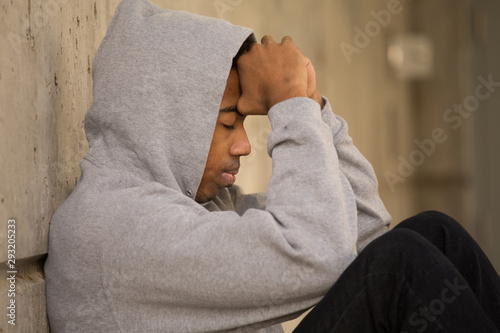 Bild auf Leinwand African American young teenage boy feeling depressed.