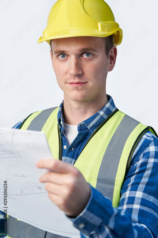 Studio Portrait Of Builder Architect Looking At Plans Against White Background Studio Portrait Of Builder Architect Looking At Plans Against White Background