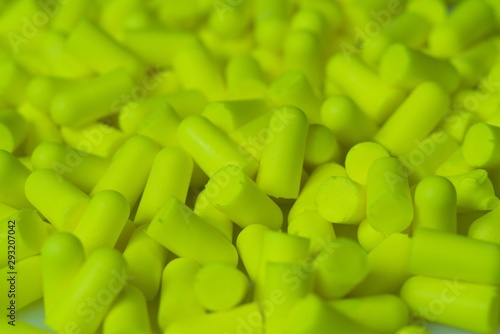 Fotografía Greenish yellow Disposable earplugs memory foam background.