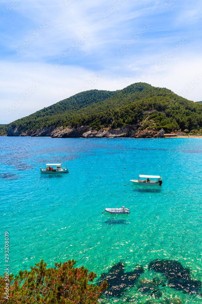 Fishing boats on azure sea water in beautiful bay of Cala Sant Vicent, Ibiza island, Spain Fishing boats on azure sea water in beautiful bay of Cala Sant Vicent, Ibiza island, Spain