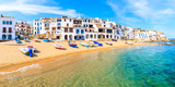 Panoramic view of fishing boats on beach in Port Bo with colorful houses of old town of Calella de Palafrugell, Costa Brava, Catalonia, Spain