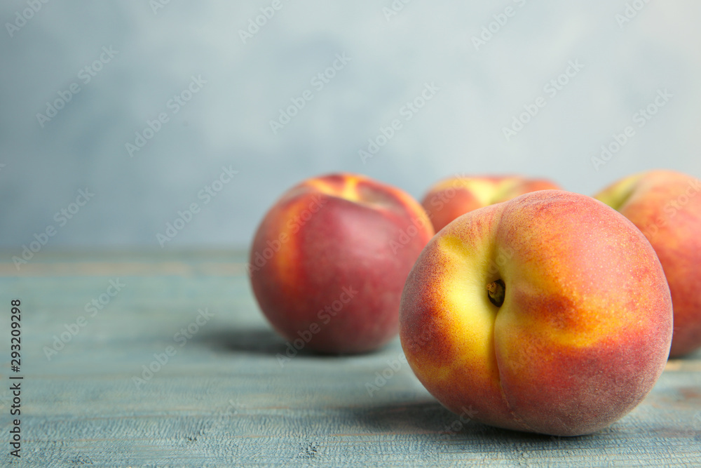 Fresh juicy peaches on wooden table against blue background, space for text Fresh juicy peaches on wooden table against blue background, space for text