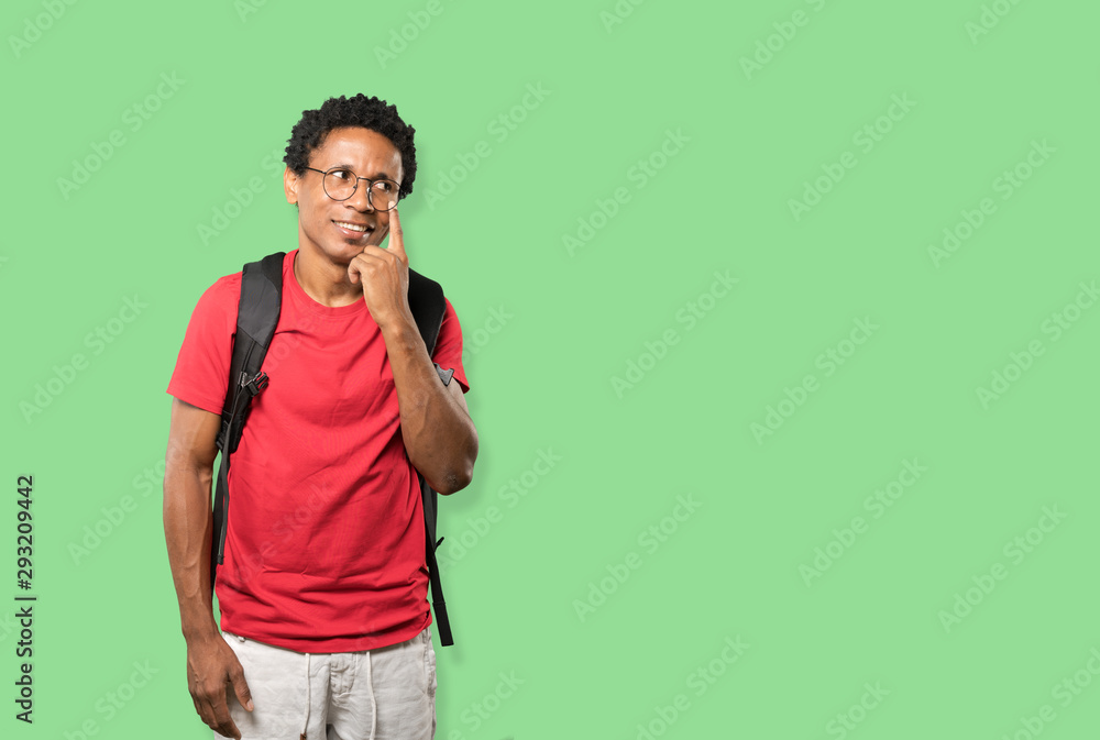 Friendly young man making a gesture of being careful with his hand pointing at his eye Friendly young man making a gesture of being careful with his hand pointing at his eye