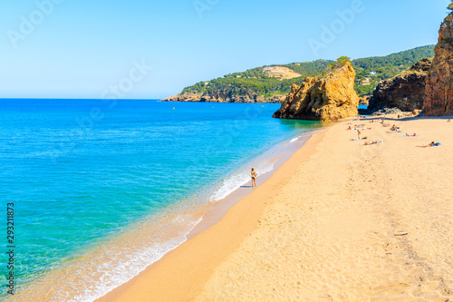 Unidentified young woman standing on Cala Moreta beach and looking at blue sea, Costa Brava, Catalonia, Spain