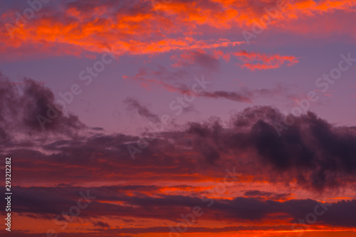 Fiery orange sunset colorful and speckled clouds.