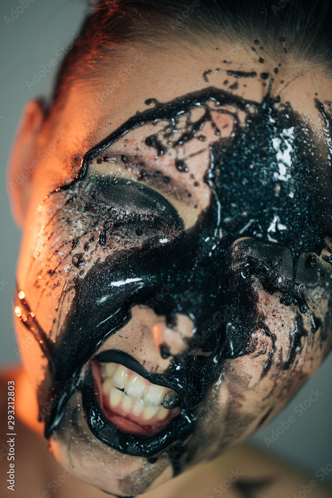 Obraz premium Stunning makeup on the face of a beautiful young girl, black drops of makeup, oil on the face and sparkles
