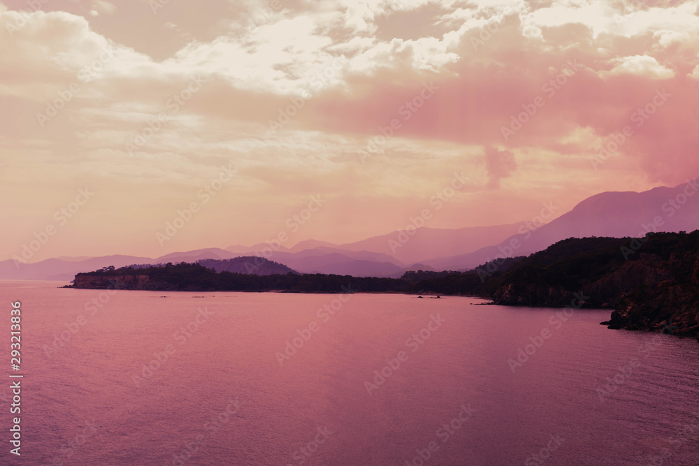 Landscape with sea, mountains and pink sky.