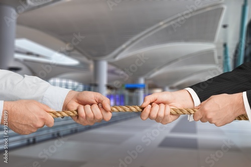 Business men hands holding rope on grey background