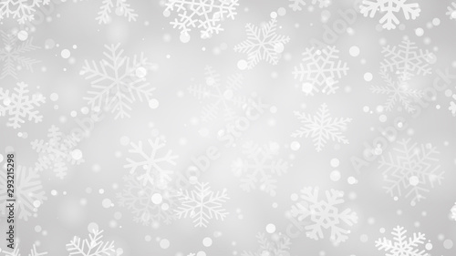 Christmas background of snowflakes of different shapes, sizes and transparency in gray colors