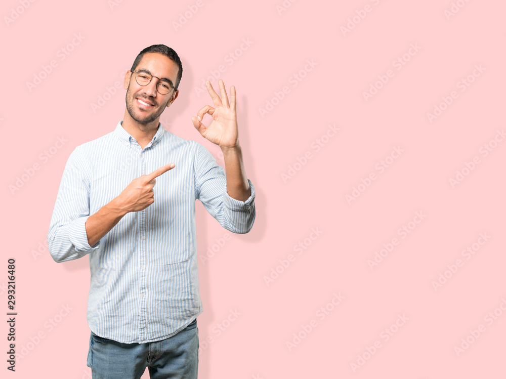 Happy young man doing an all right gesture