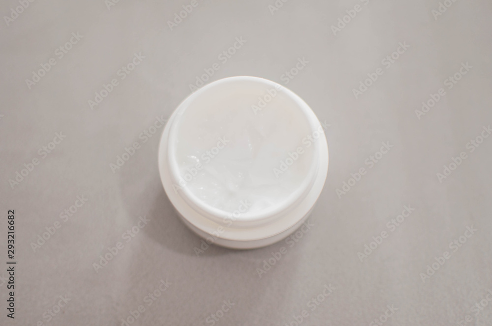 A beauty cream on a plastic container on a gray background A beauty cream on a plastic container on a gray background