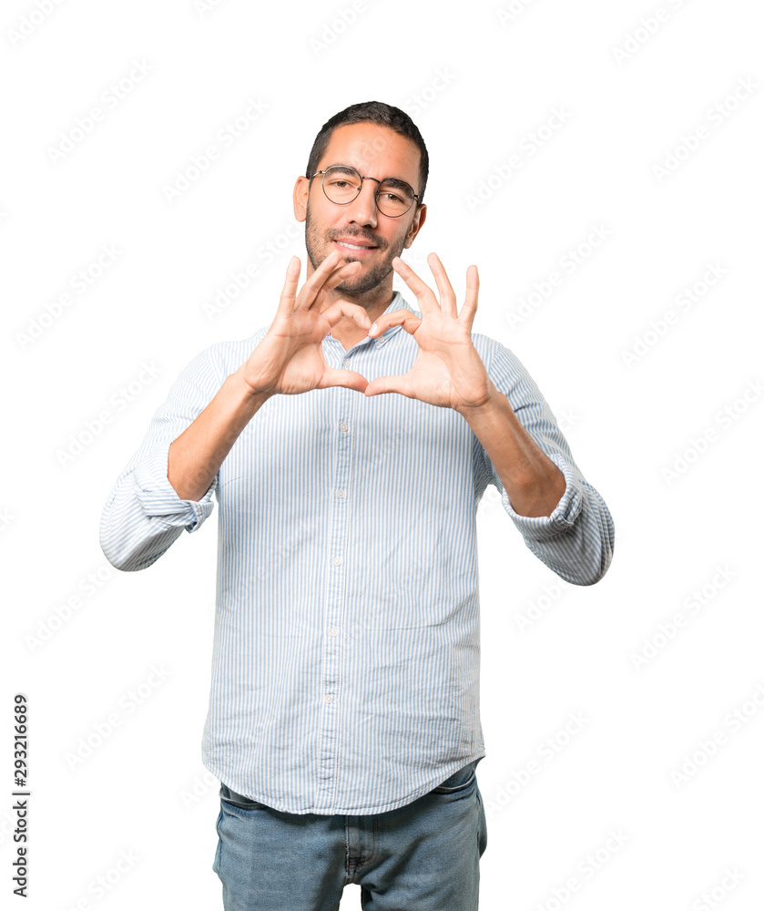 Happy young man doing a gesture of love with his hands Happy young man doing a gesture of love with his hands