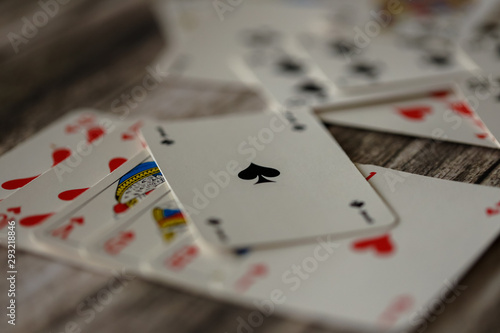 Combination of playing card on wooden background, royal flash covered by ace of spades