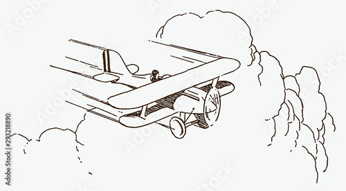 Historical single-seater biplane flying fast in front of large cumulus clouds