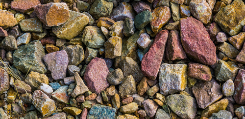 gravel stones in diverse colors in closeup, stone pattern background © Charlotte B