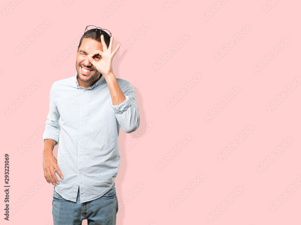 Amazed young man using his hands like a binoculars Amazed young man using his hands like a binoculars