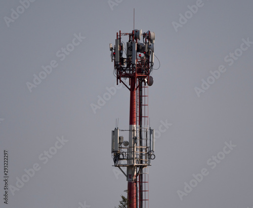 Telecommunication tower with antennas against with blue skyand white cloud background photo