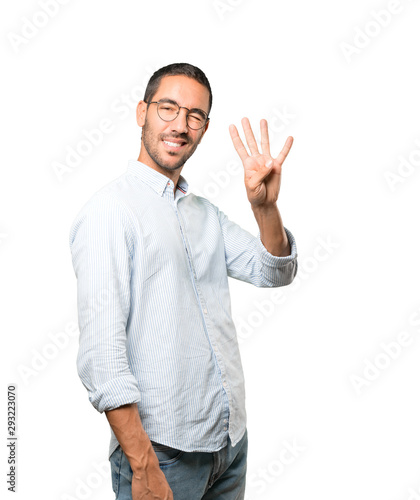 Young man making a number four gesture