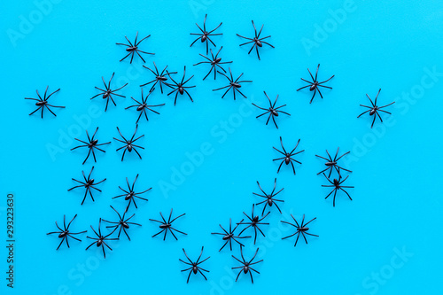 Minimalistic Halloween frame with small spiders on blue background top view copy space mockup frame