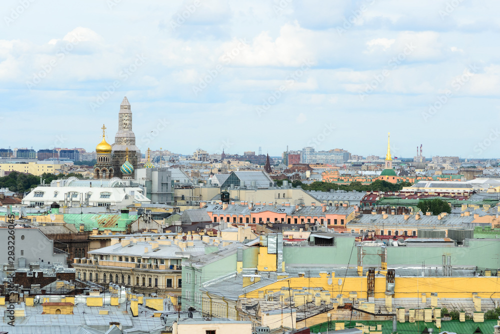 Cityscape view of Saint Petersburg, Russia. In the middle of the city roofs emerge the Church of the Savior of the Spilled Blood, under renovation at this time
