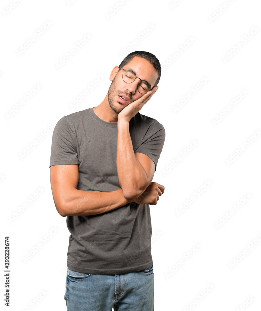 Relaxed young man making a gesture of sleep Relaxed young man making a gesture of sleep