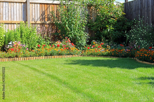 Fotografija Summer Flower Borders Surrounding A Grass Lawn In An Enclosed Home Garden