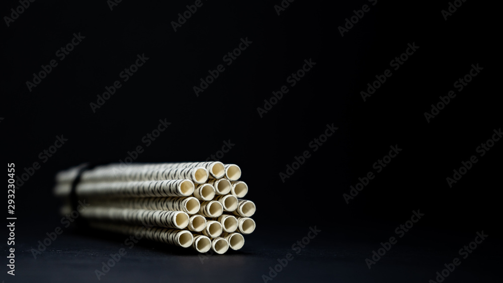 White paper straws isolated on black background