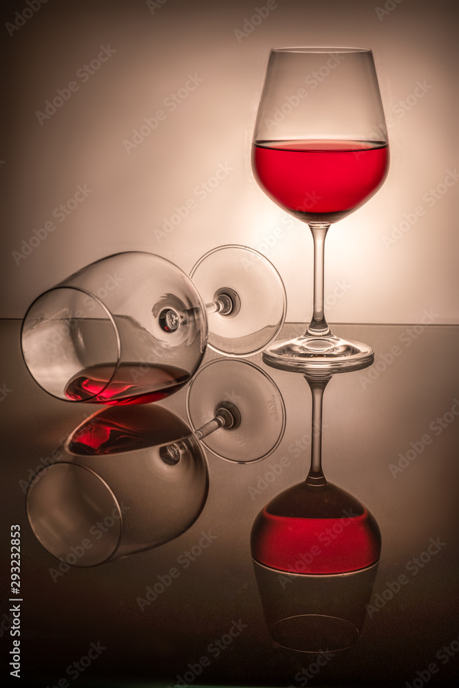 one glass half full the second lies, spilled wine, two red wine glasses on  a white background. Stock Photo | Adobe Stock
