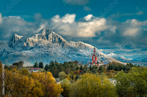 Red Buksnes church in front of snowy mountains at Lofoten Islands