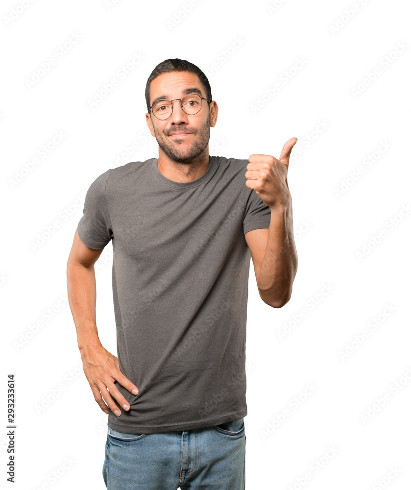 Hesitant young man gesturing that everything is fine Hesitant young man gesturing that everything is fine