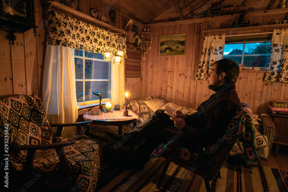 Young man in a Cozy old cabin on Senja Island