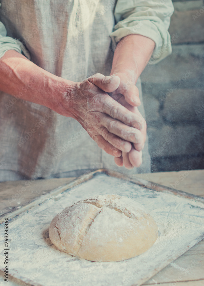 The Baker's hands. Process the dough for wheat bread. Rustic style. Selective focus