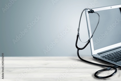 Laptop diagnosis with  stethoscope  on background photo