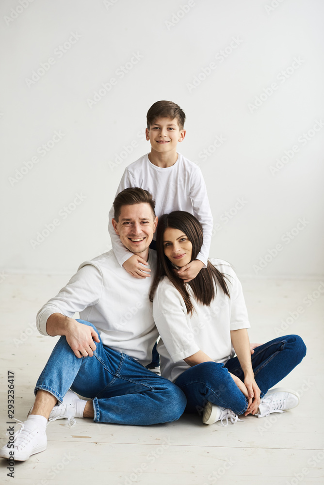 A beautiful young family in the morning bedroomis relaxing and have a fun on a white background A beautiful young family in the morning bedroomis relaxing and have a fun on a white background