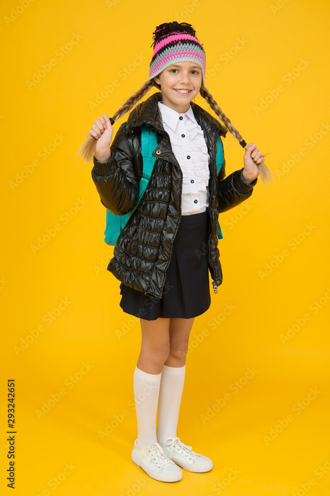 Fashion concept. Warm clothing. Buy clothes for school season. Schoolgirl fashion outfit. Fall autumn winter. Child with backpack. Fashion shop. Girl wear knitted hat and jacket yellow background Fashion concept. Warm clothing. Buy clothes for school season. Schoolgirl fashion outfit. Fall autumn winter. Child with backpack. Fashion shop. Girl wear knitted hat and jacket yellow background