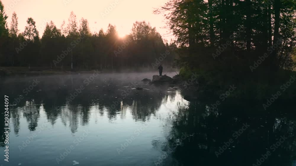 Möhkö, Finland - 18 August 2019: Fisher man fishing with spinning rod on a river bank at misty foggy sunrise Möhkö, Finland - 18 August 2019: Fisher man fishing with spinning rod on a river bank at misty foggy sunrise
