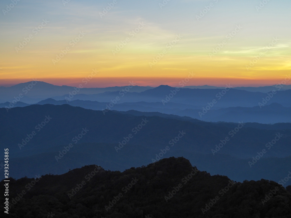 Beautifully graded twilight at Chiang Dao Mountain, the horizon line is orange. Many mountains are dark blue and light. Beautifully graded twilight at Chiang Dao Mountain, the horizon line is orange. Many mountains are dark blue and light.